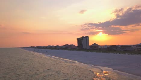 Eine-Dramatische-Luftaufnahme-Des-Sonnenuntergangs-Am-Strand-Mit-Auffälligen-Farben