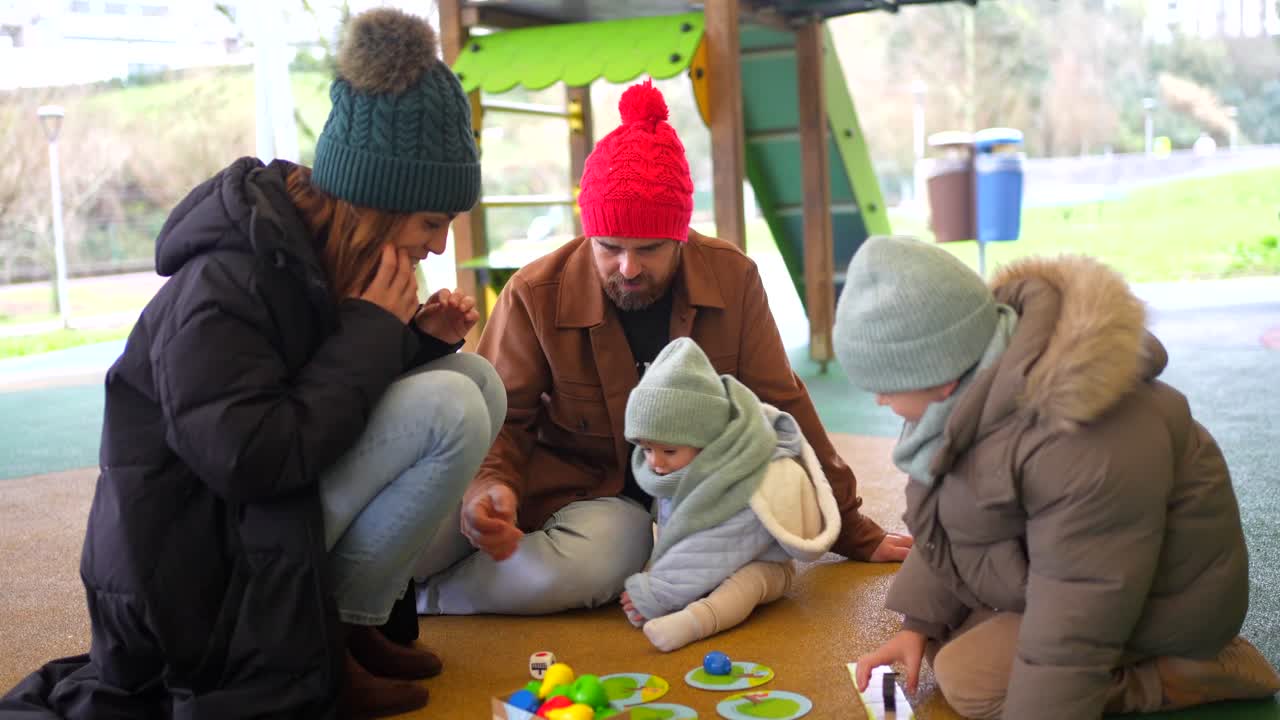 Family playing at the playground in winter