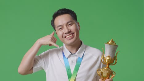 man celebrating with trophy and gesture