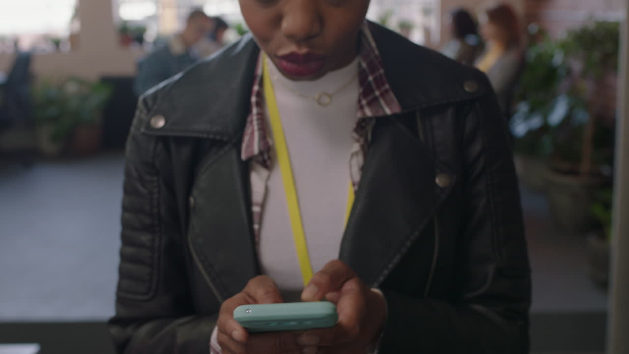 primer plano feliz mujer de negocios afroamericana usando teléfono inteligente navegando mensajes de redes sociales enviando mensajes de texto en el teléfono móvil disfrutando de un lugar de trabajo de oficina diverso mujer gerente caminando con confianza