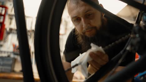 bicycle mechanic cleaning bike chain with tissue