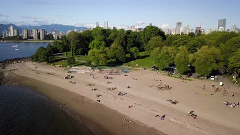 Menschen-Genießen-Im-Sommer-Den-Wiedereröffneten-Strand-Von-Kitsilano-Mit-Der-Skyline-Der-Innenstadt-Und-Dem-English-Bay-Beach-In-Vancouver,-Britisch-Kolumbien,-Kanada