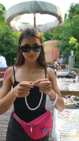 young woman shopping for jewelry at an outdoor market