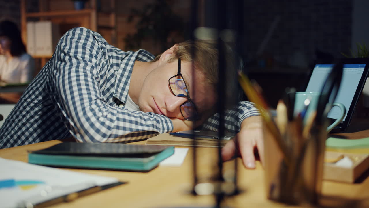 Tired employee sleeping at his desk
