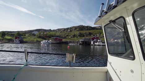 Sailing-Fishing-Boat-Passing-Through-Small-Cottages-Along-Calm-Ocean-And-Lush-Mountains-In-Norway