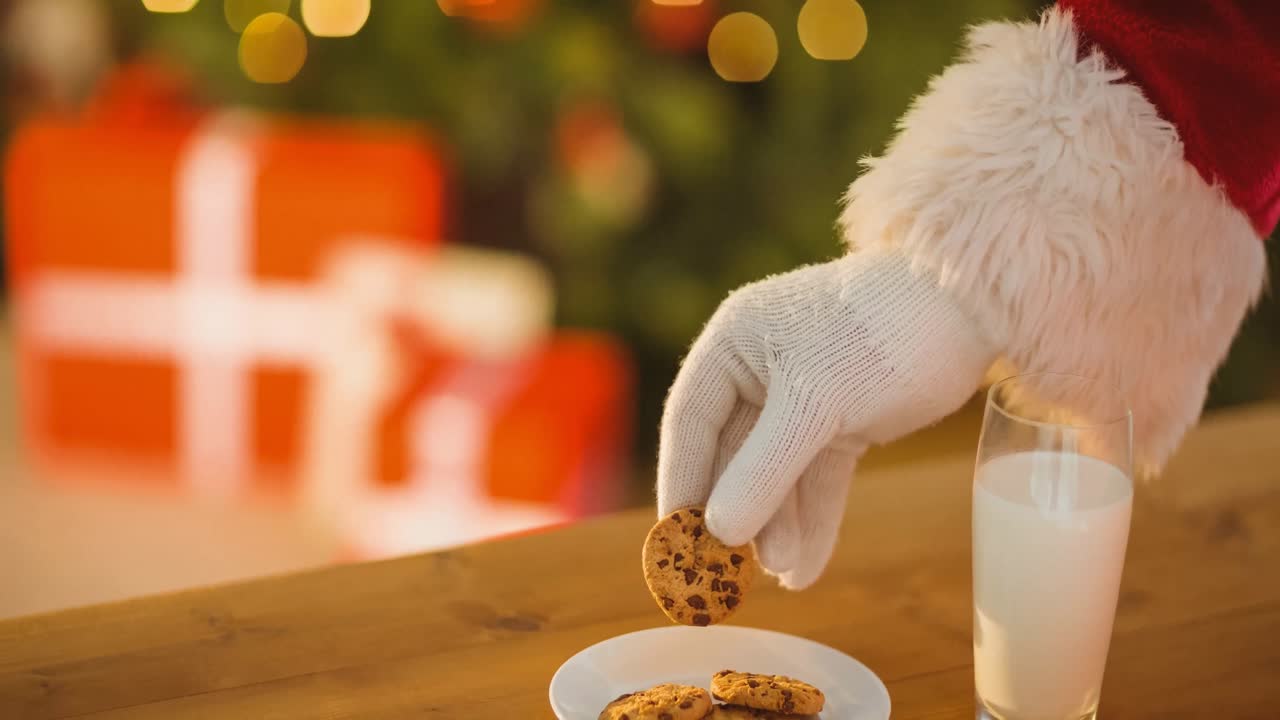 animación de la mano de santa claus tomando galletas de navidad del plato