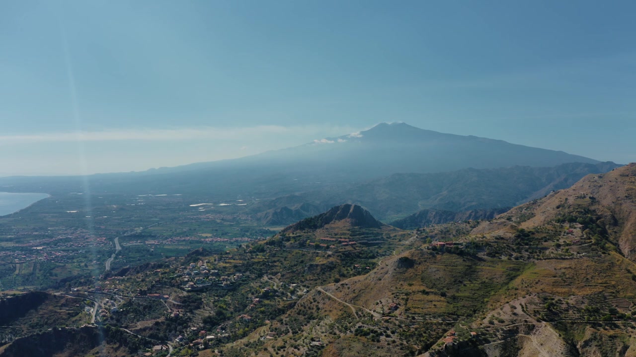 Volando sopra un'area montuosa con una chiara vista della cima dell'Etna. Panorami mozzafiato in Sicilia, Italia.