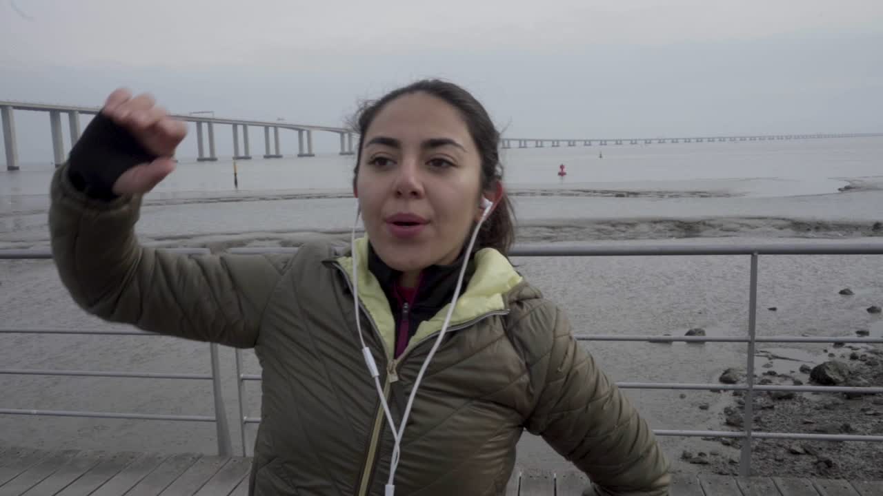 mujer joven enfocada con auriculares calentándose antes del entrenamiento