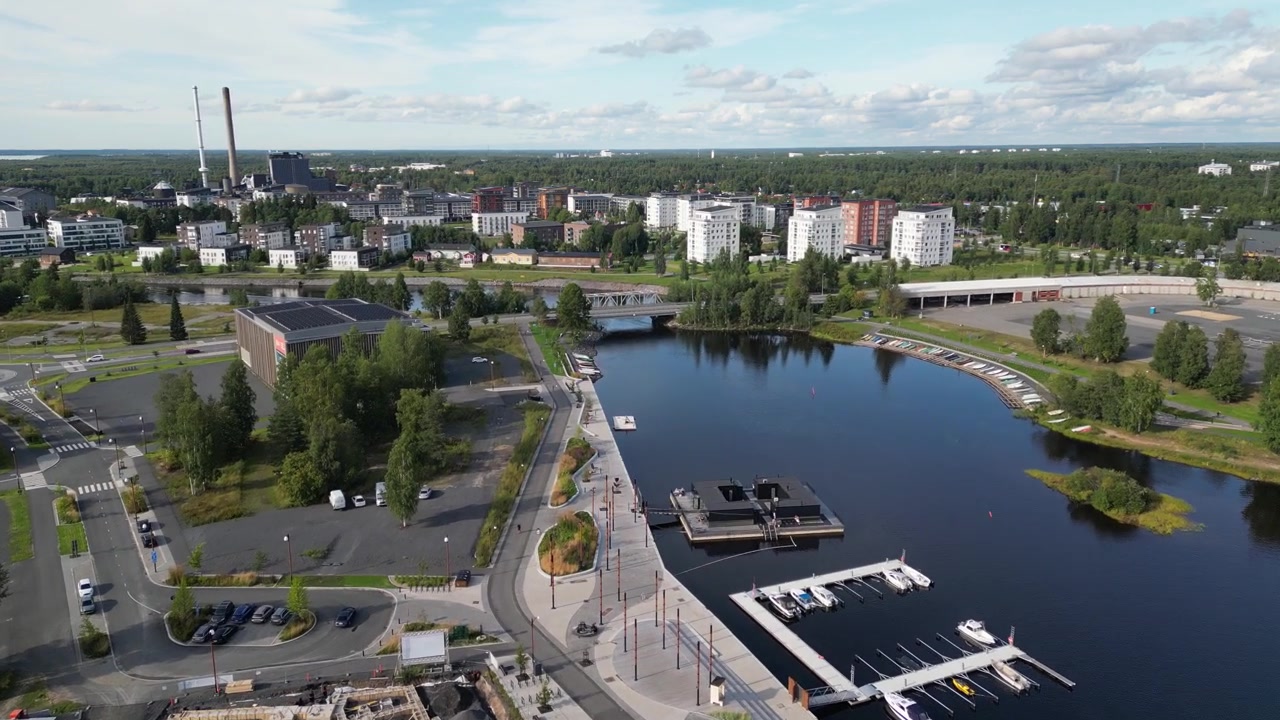 Dronevideo, joka kuvaa luonnonkauniin Toppilansalmen ja Hartaansillan Oulussa, Suomessa, aktiivisen asuinkerrostalon rakennustyömaan vieressä.