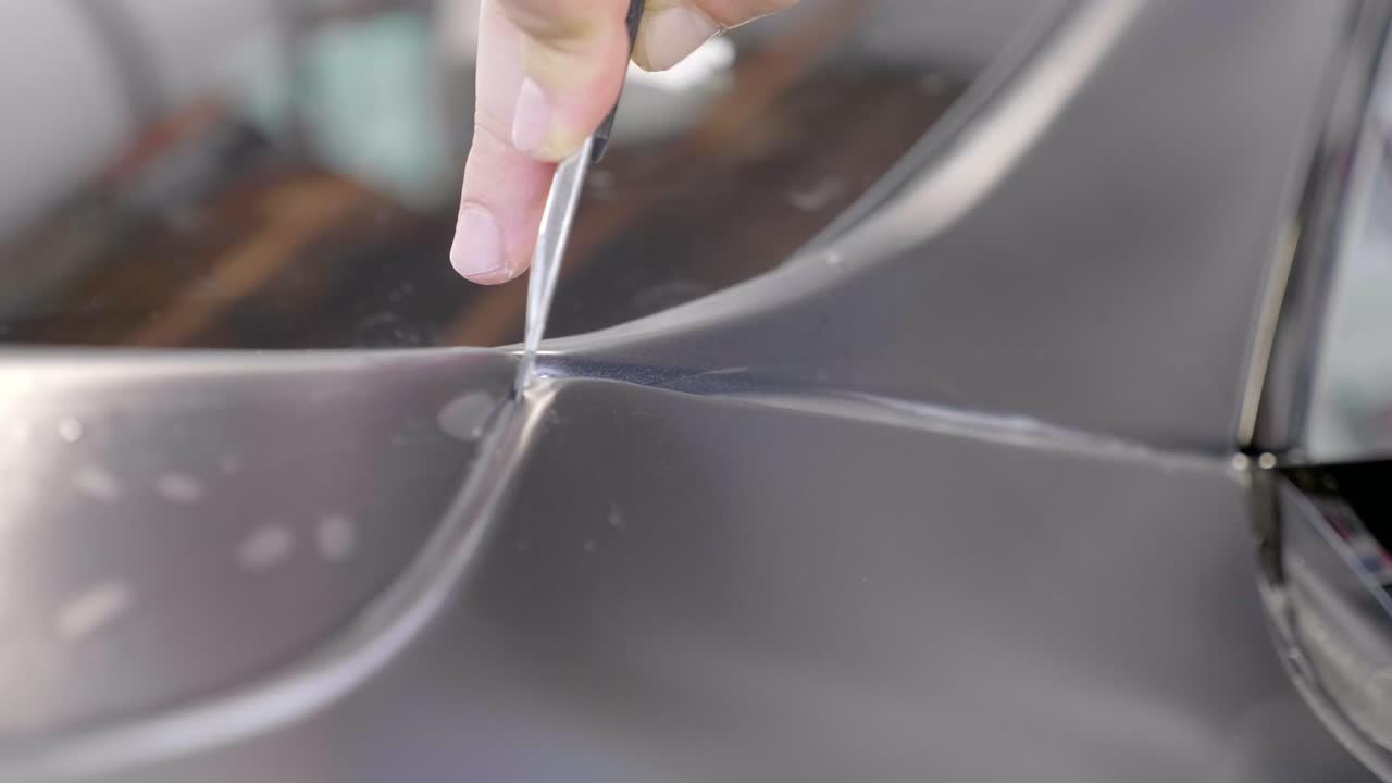 cortar la lámina de envoltura de automóviles en el maletero del vehículo con un cuchillo stanley