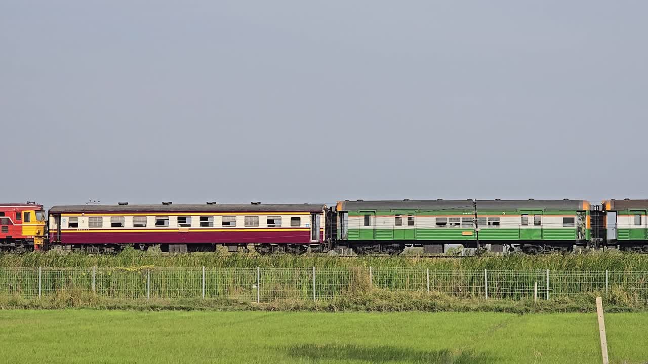 Treno a locomotiva classico che attraversa campi di riso a Cha-Am, Thailandia