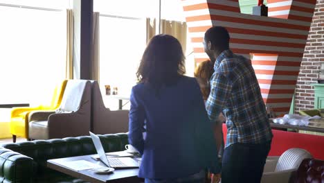 concepto de negocios, startups y personas - equipo creativo feliz con computadoras y carpetas discutiendo proyectos en un espacio compartido en el loft.