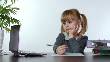 preschool child girl distance online learning at home. kid studying using digital laptop computer