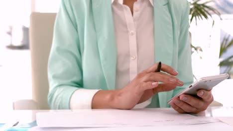 Businesswoman-calculating-at-her-desk