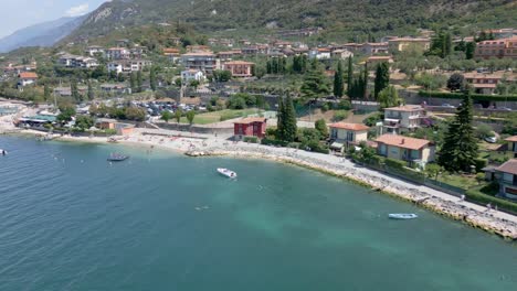 Toma-Aérea-Acercándose-Lentamente-A-Las-Costas-De-La-Hermosa-Ciudad-Italiana-De-Malcesine