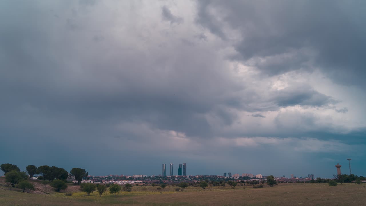 timelapse cielo nublado y tormentoso en el horizonte de madrid durante el atardecer de día a noche luces de la ciudad
