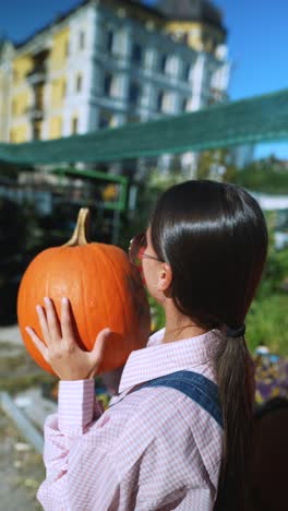 woman holding pumpkin at a market