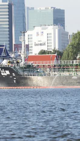 barco de carga moviéndose a lo largo de la orilla del río de la ciudad