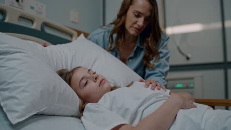 mother by her sick daughter's bedside in the hospital