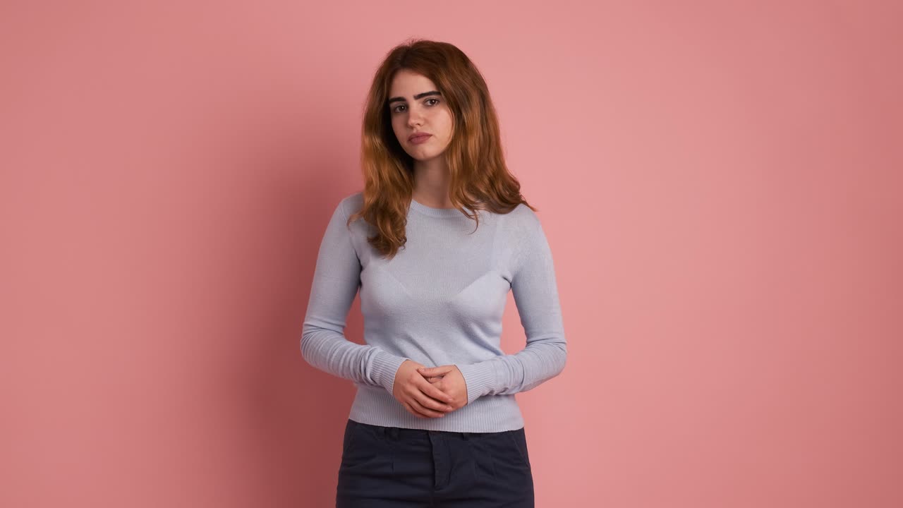 Sad young woman looking at camera with thoughtful expression