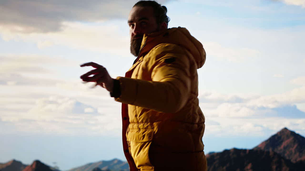 Un allegro escursionista celebra l'arrampicata nell'aspra natura selvaggia con una danza della vittoria