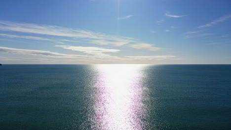 aerial flying over ocean during sunny day background, dolly movement