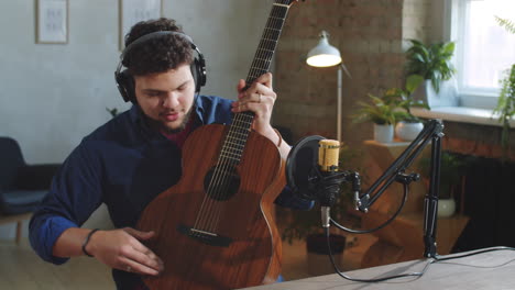 male musician giving online guitar class in studio