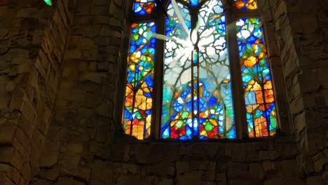 sunlight streaming through a vibrant stained glass window in a church creates a beautiful display of color and light