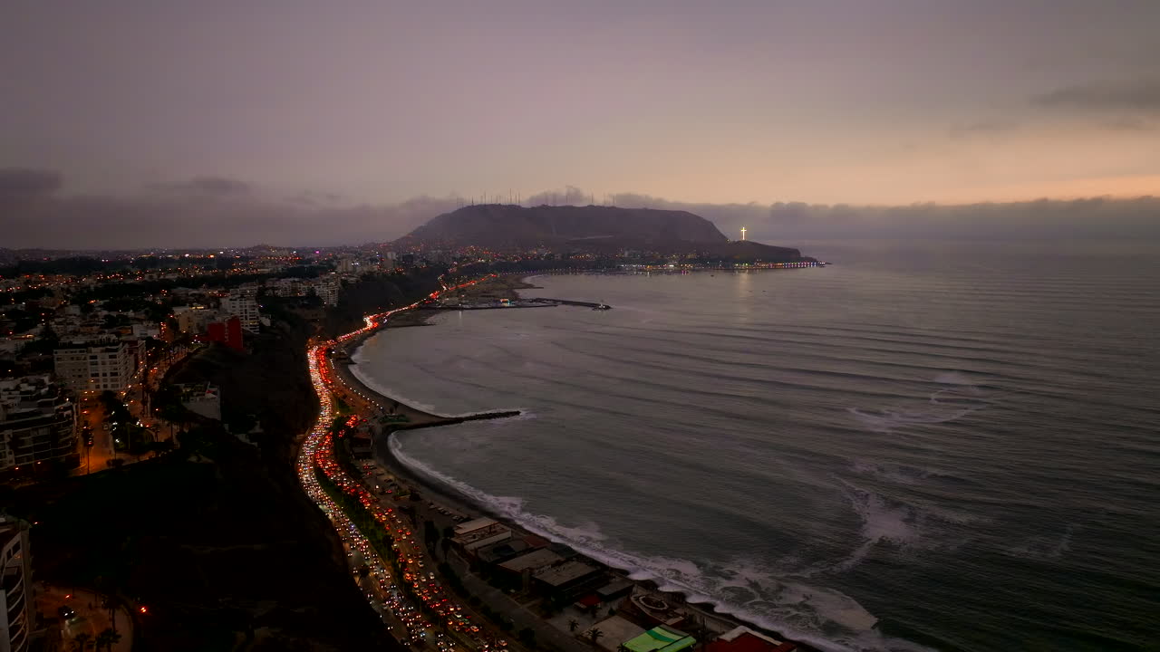 Twilight aerial view of traffic flowing on Lima coastline next to Costa Verde
