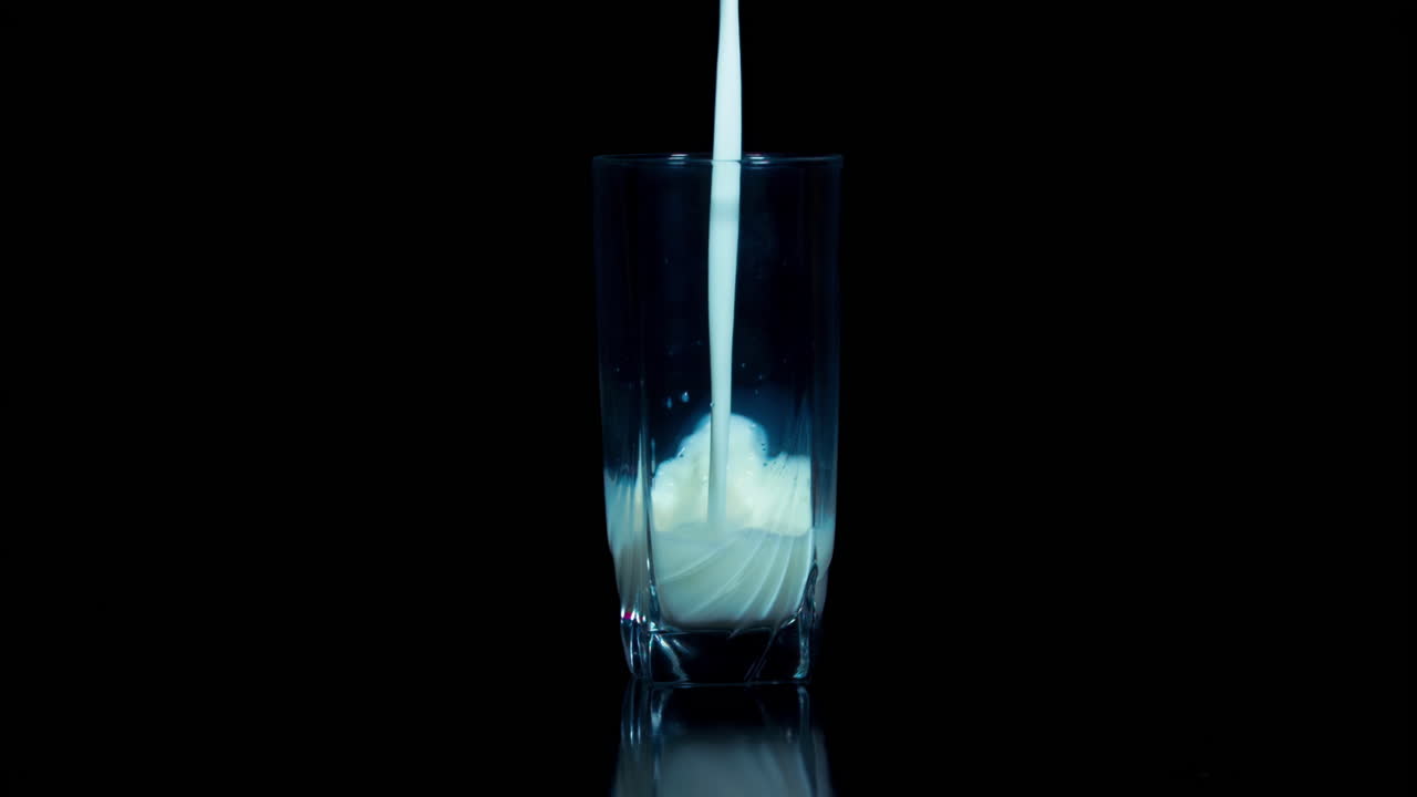 Milk is poured into the glass in slow action