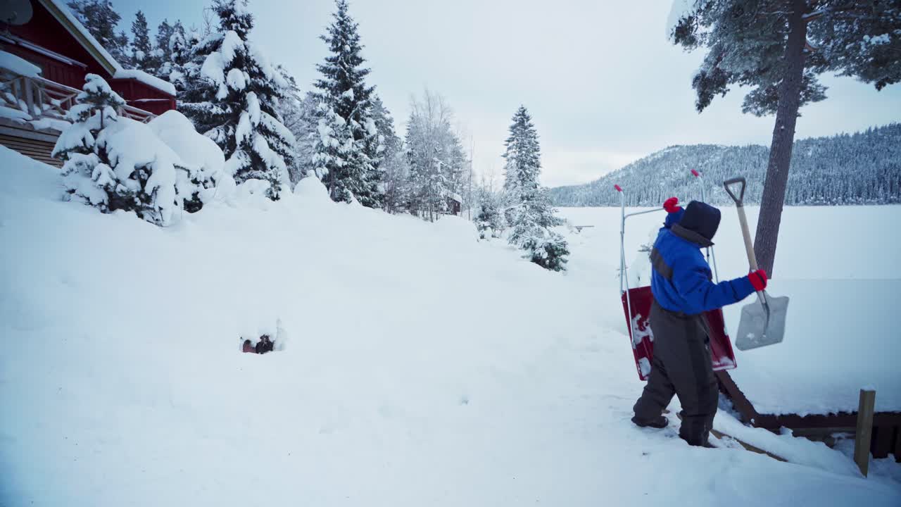hombre que lleva una pala y una pala de nieve de trineo en el paisaje invernal del campo cerca de trondheim, noruega