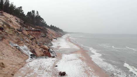 Luftaufnahme-Von-Wellen,-Die-Im-Winter-In-Den-Sandstrand-Von-Ustka-Schlagen