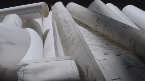 paper rolls of construction plans lying on the floor in the shade