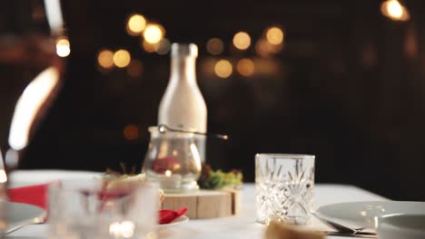 Fine-dining-scene-as-elegant-woman-raises-champagne-glass-off-of-table-in-upscale-restaurant