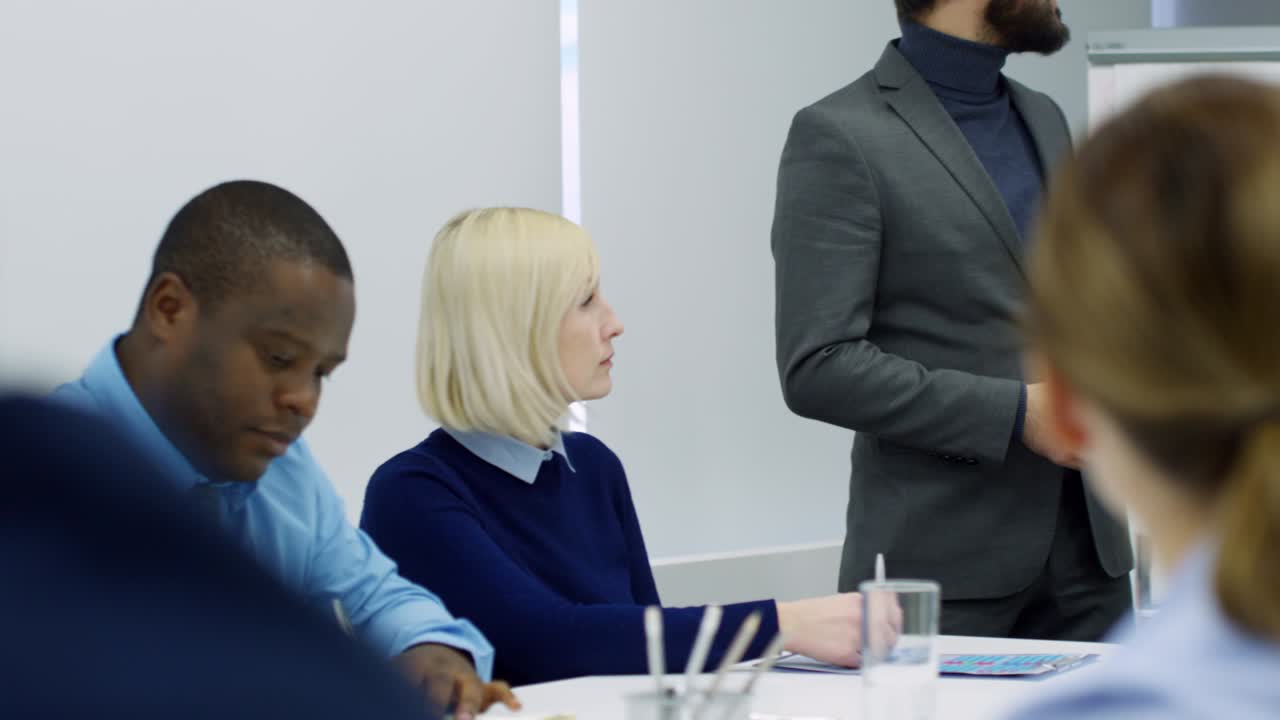 Asian Manager Giving Presentation at Flipchart to Business Team