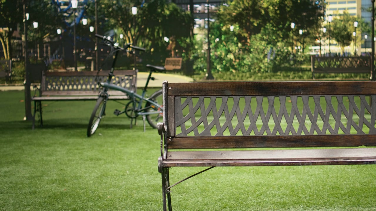 Wooden park bench standing in empty urban park with lush greenery