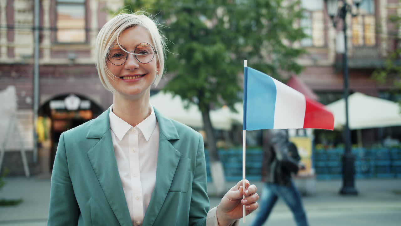 Woman holding French flag in city street
