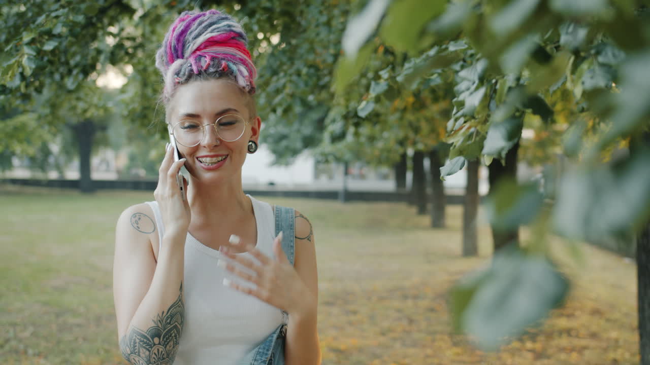 Young Woman Talking on Phone in a Park