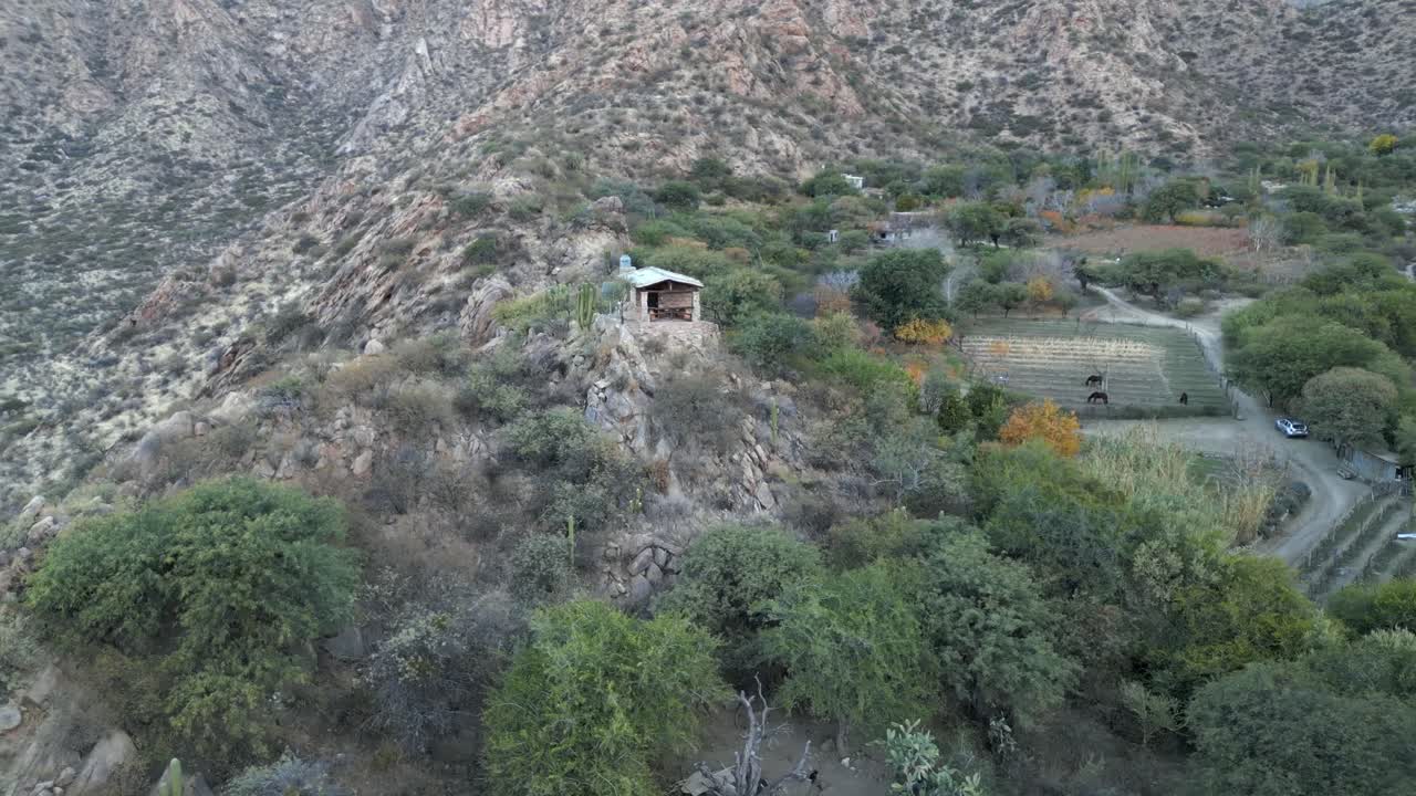 pequeña casa o granja en un montículo rodeado de campos de cultivo