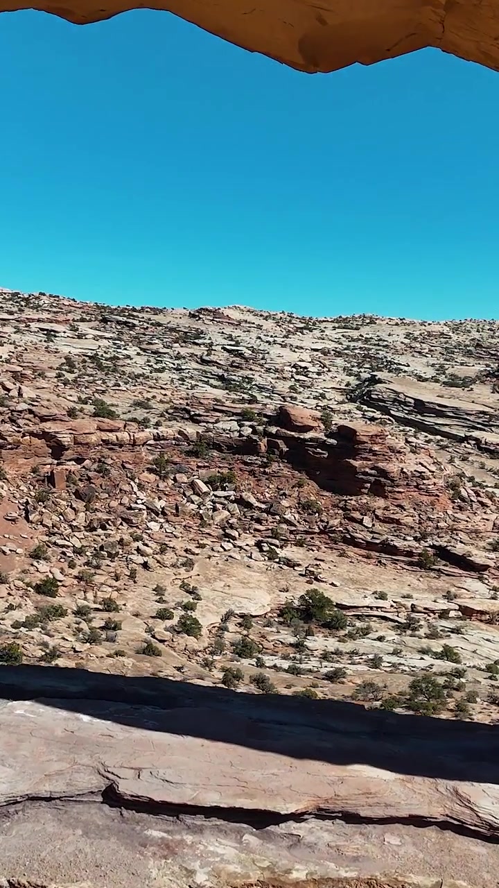 Vista verticale, volo attraverso un arco panoramico nel deserto dello Utah, ripresa da drone del Jeep Arch a Moab, USA