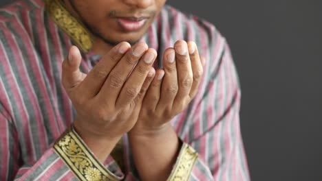 muslim man keep hand in praying gestures during ramadan, close up