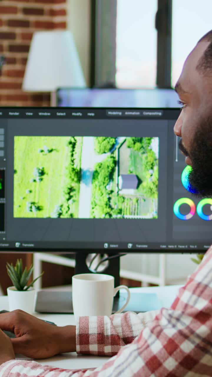 Video verticale: un creatore di video maschile modifica un progetto multimediale in un ufficio moderno
