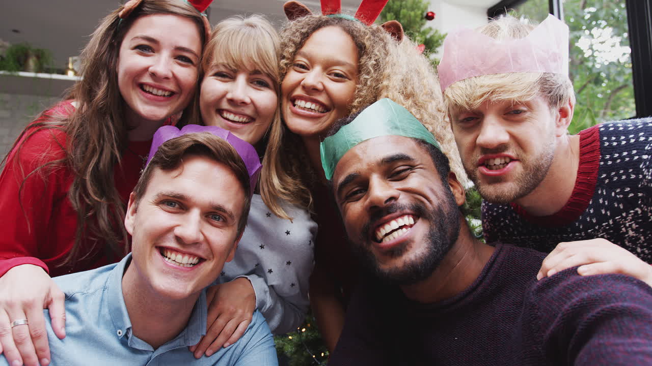grupo de amigos disfrutando de la fiesta de navidad en casa juntos tomando una selfie