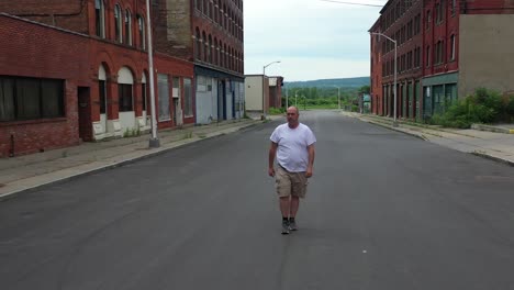 hombre caminando hacia la cámara calle americana abandonada