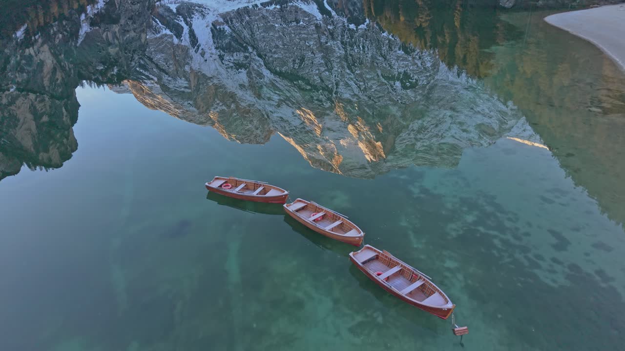 Vacker drönarbild av Lago di Braies i Dolomiterna med båtar och spegelblankt vatten