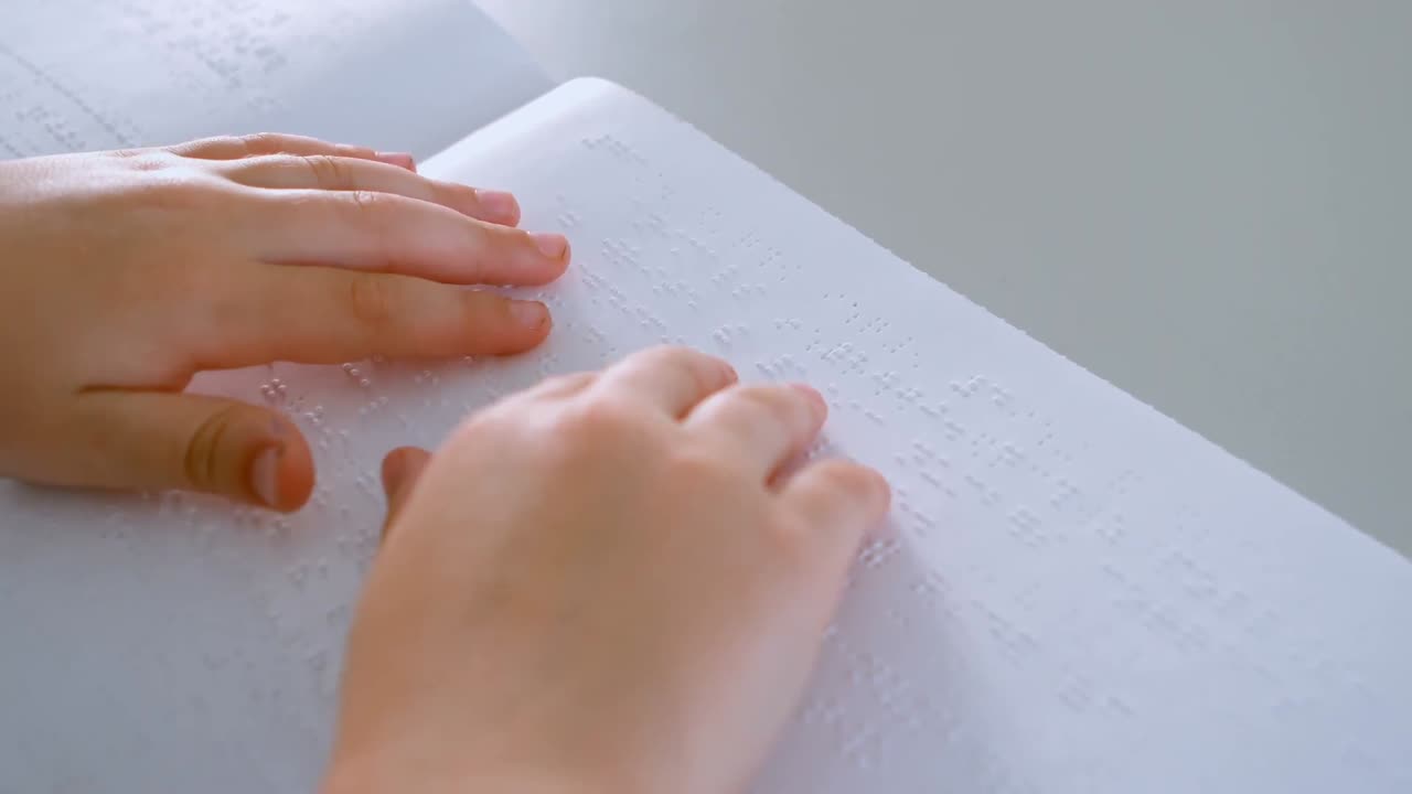 niño de escuela caucásico ciego manos leyendo un libro en braille en el escritorio en el aula en la escuela 4k