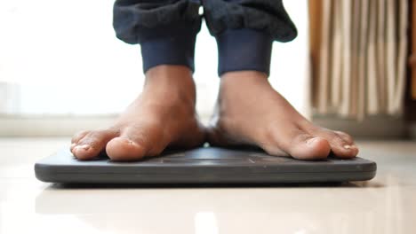 los pies del hombre en la balanza de peso de cerca