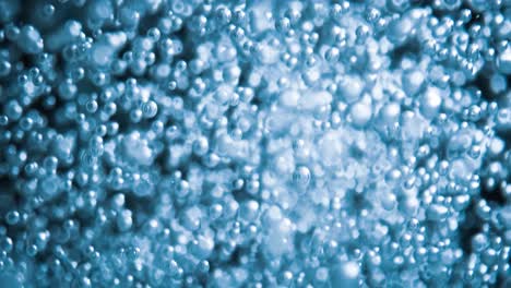 many water bubbles in blue water close up, abstract water wave with bubbles in slow motion.