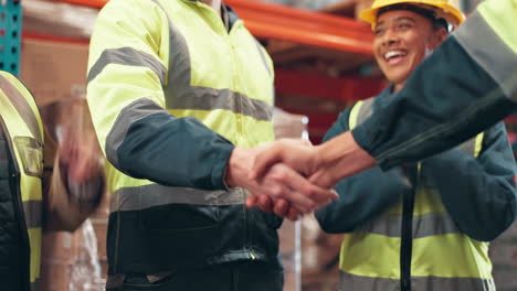warehouse workers celebrating success with a handshake