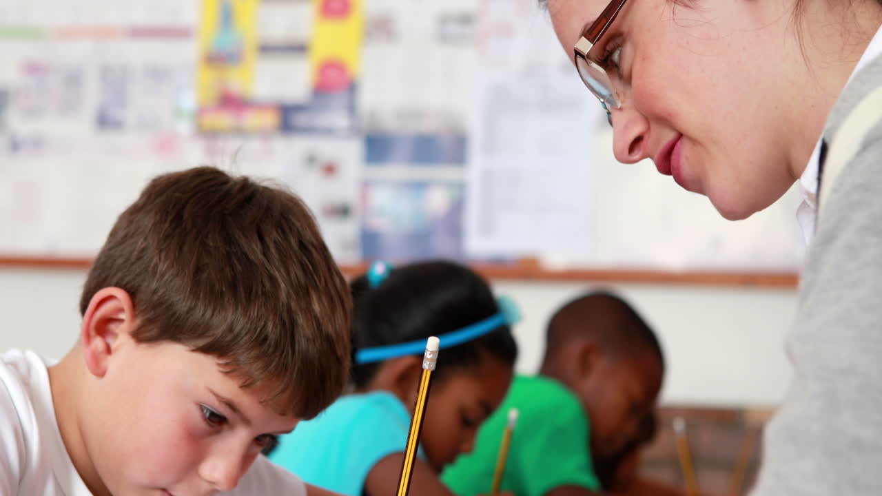 maestra ayudando a un niño pequeño durante la clase